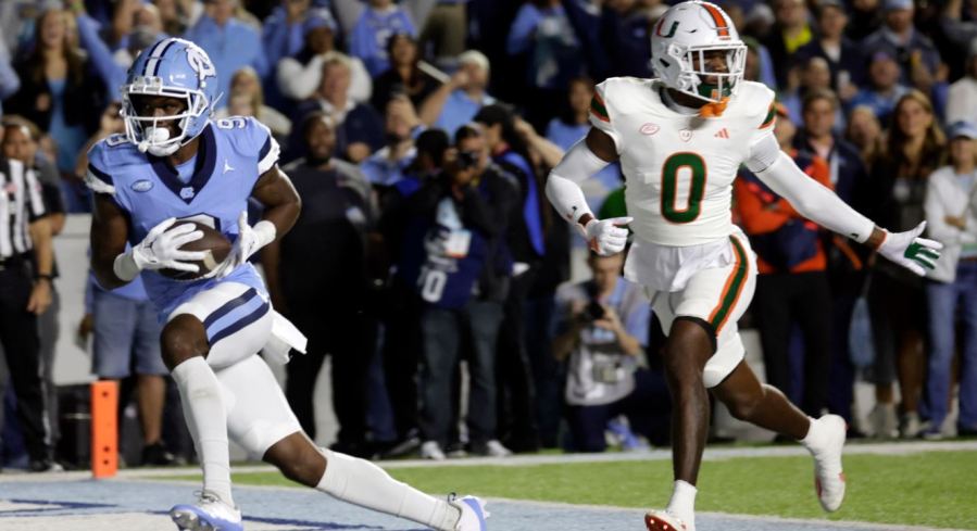 North Carolina wide receiver Devontez Walker (9) hauls in a touchdown pass against Miami cornerback Te'Cory Couch (0) during the first half an NCAA college football game Saturday, Oct. 14, 2023, in Chapel Hill, N.C. (AP Photo/Chris Seward)